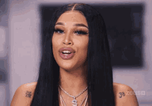 a woman with long black hair has a tattoo on her arm that says 3 zeus