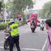 a man in a security vest holds a stop sign
