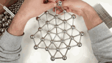 a person is playing with a magnetic toy which looks like a molecule