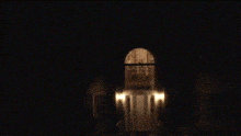 a dark room with a few lights shining through the window