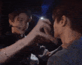 two men are making a heart shape with their hands while standing next to each other .