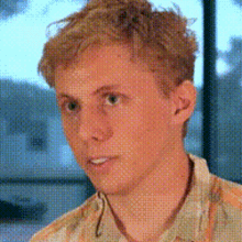 a close up of a young man 's face in front of a window