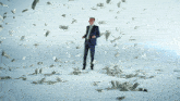 a man in a suit and tie stands in a field of money