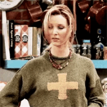 a woman is wearing a sweater with a cross on it .