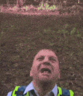 a man wearing a yellow vest and tie with his mouth wide open