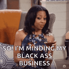 a woman is sitting in a chair holding a glass of wine and saying `` so i 'm minding my black ass business ''