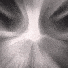 a black and white photo of a light coming out of a tunnel