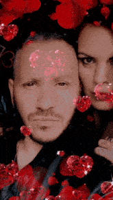 a man and woman are posing for a picture with red hearts on their faces