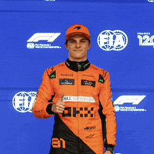 a man in an orange racing suit with the number 81 on his chest