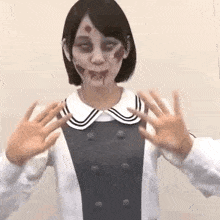 a woman in a zombie costume is making a funny face with her hands .