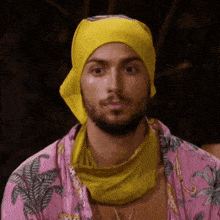 a man wearing a yellow bandana and a pink shirt