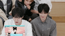 a group of young men sitting on a couch with one wearing a shirt that says " bal "