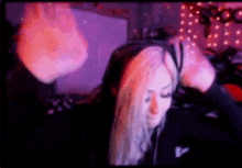 a woman with long blonde hair is sitting in front of a computer screen with a fireball in the background .