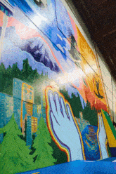 a large mural on a wall shows a city and a river