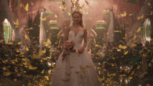 a woman in a white wedding dress is surrounded by gold confetti
