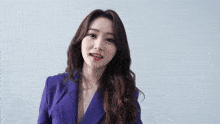 the woman is wearing a purple jacket and red lipstick .