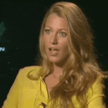 a woman wearing a yellow jacket is making a funny face