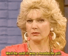 a woman is wearing earrings and a red shirt and says well he said it was a headache pill .