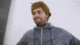 a man wearing a grey adidas hoodie looks at the camera