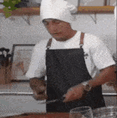 a man wearing a chef 's hat and apron is cutting a piece of meat with a knife