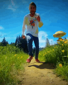 a man wearing a shirt that says ' king ' on it is running on a dirt path