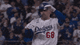 a dodgers baseball player wearing number 68 is standing in front of a crowd