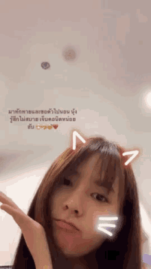 a girl with a cat ear on her head is making a face
