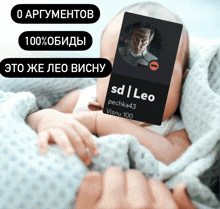 a baby is being held by a person with a card that says sd | leo on it