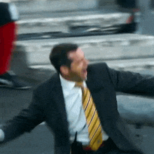 a man in a suit and tie is jumping in the air with his arms outstretched
