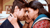 a woman touches a man 's face while they look into each others eyes