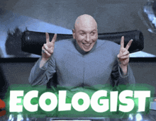 a bald man is giving a peace sign in front of a green sign that says ecologist