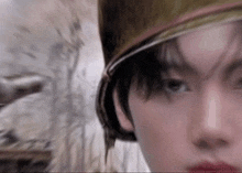 a close up of a person 's face with a scarf around their head