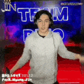 a man wearing headphones is dancing in front of a sign that says team