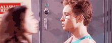 a man and a woman are standing next to each other in front of a locker with a sign on it that says allway run