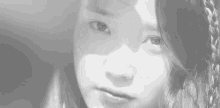 a close up of a woman 's face in a black and white photo with a shadow on her face .