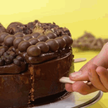 a person is taking a piece of chocolate cake