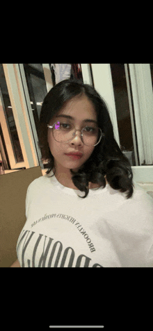 a girl wearing glasses and a white shirt that says brooklyn