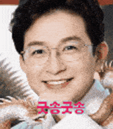 a close up of a man wearing glasses and smiling with chinese writing .