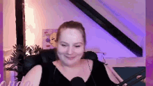 a woman is sitting in a chair with a microphone in front of her .