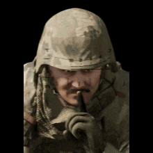 a man in a military uniform is holding his finger to his lips