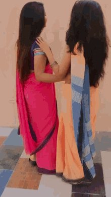 two women are standing next to each other wearing different colored dresses