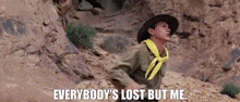 a man in a cowboy hat and yellow scarf is crawling out of a hole in the ground .