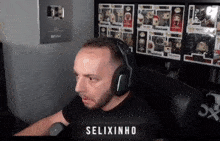 a man wearing headphones is sitting in front of a shelf full of funko pop figures ..