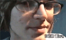 a close up of a person 's face wearing glasses and a hat