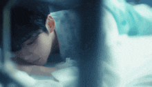 a man in a hospital gown is laying on a bed with his head on his hand