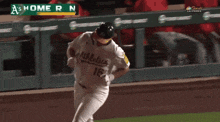 a baseball player is running on the field with a home run sign behind him