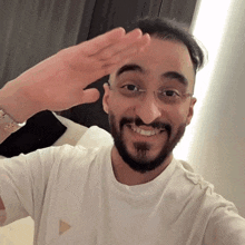 a man with a beard wearing a white shirt with a triangle logo on it