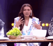 a woman sitting at a table with bowls and plates