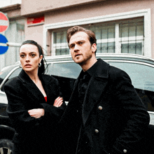 a man and a woman standing next to a car