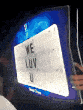 a sign that says we luv u is being held up